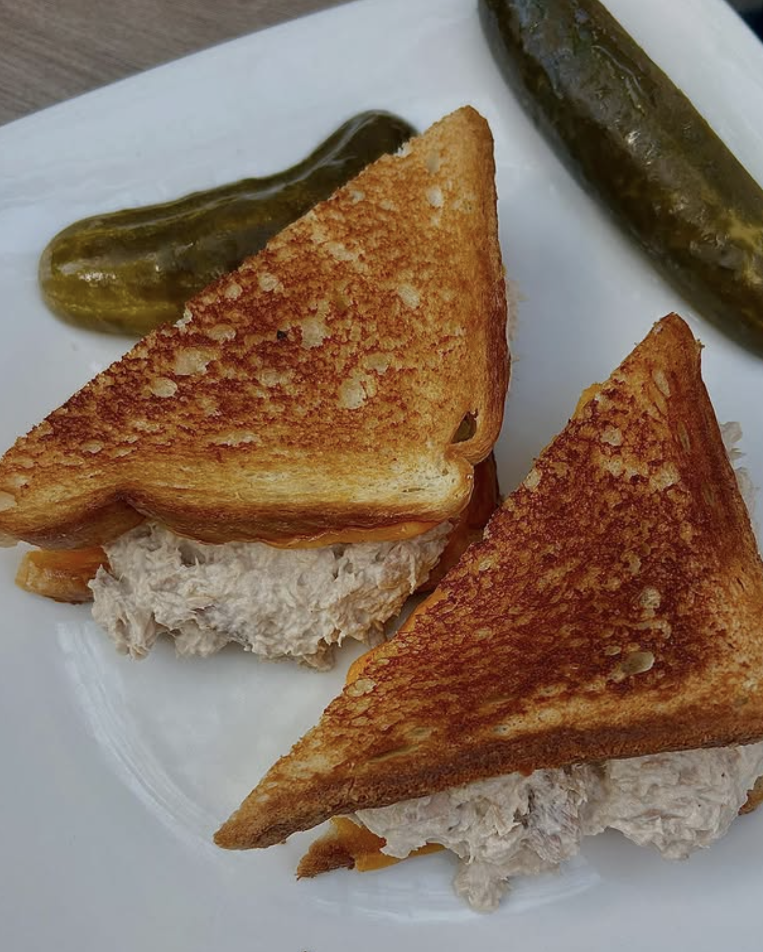 Grilled sandwich triangles with pickles.