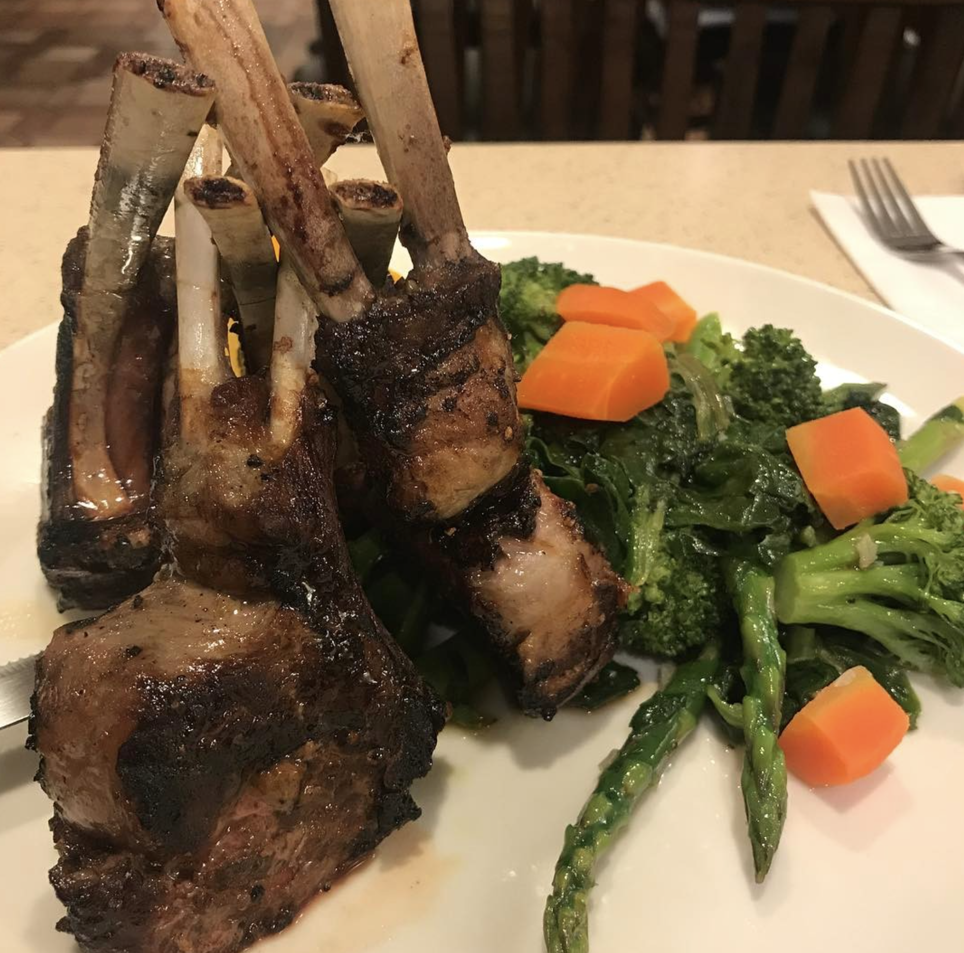 Grilled lamb chops with broccoli, carrots, greens, and asparagus.