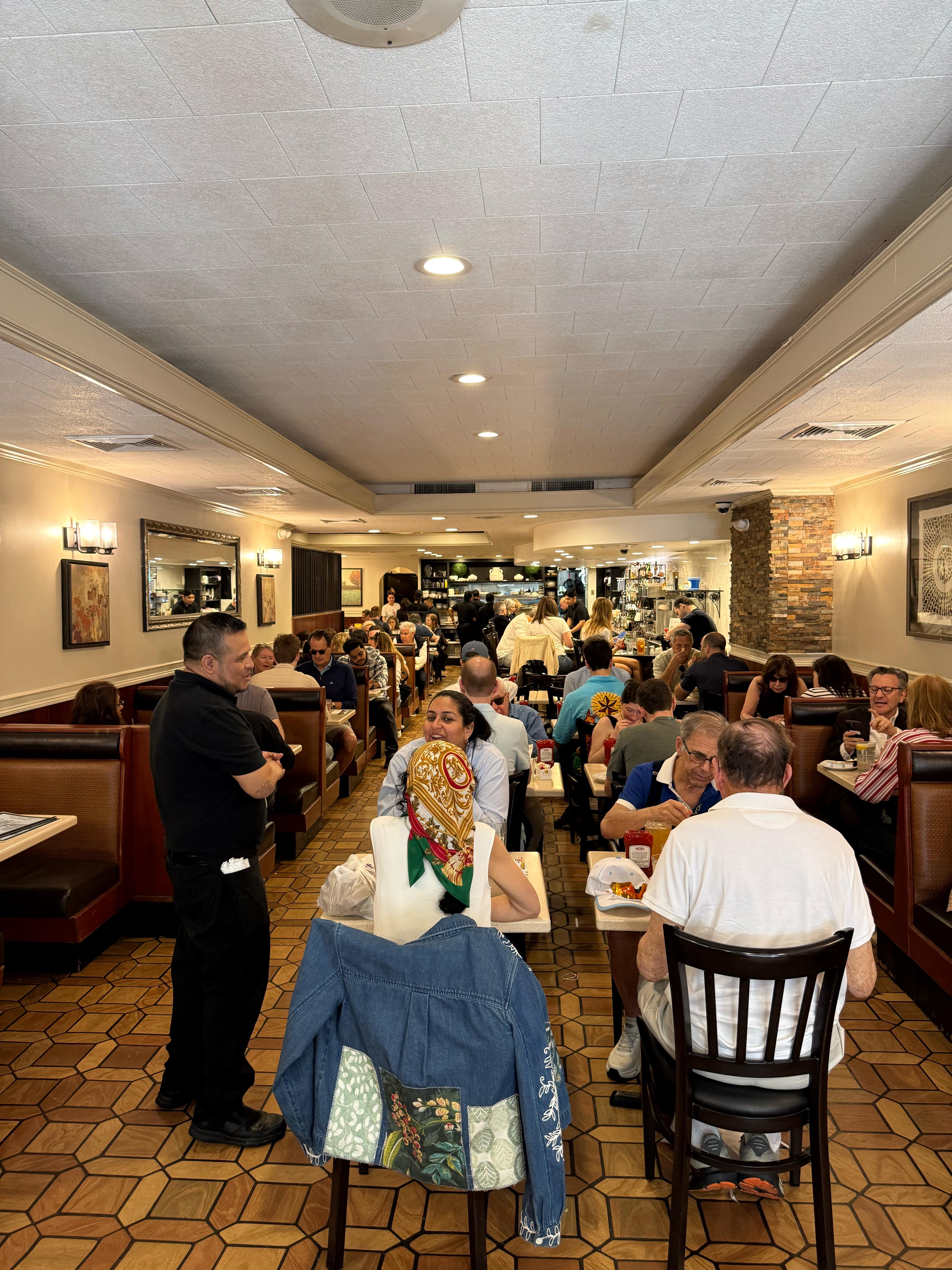 Three Guys dining room with booths, counter seating, and warm pendant lights.